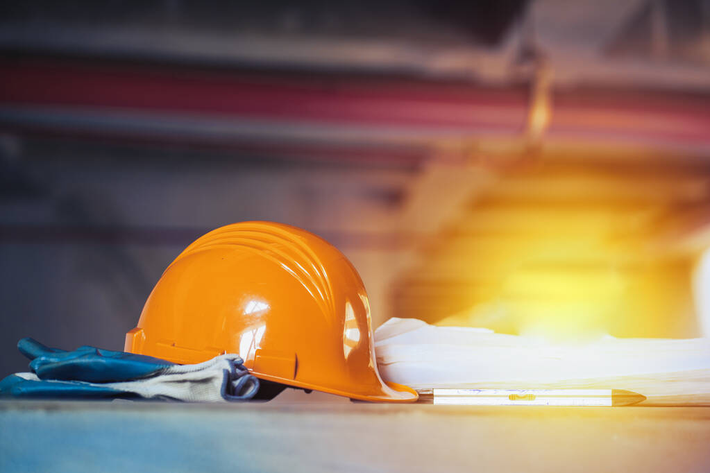 Orange hard hat and gloves on a construction site